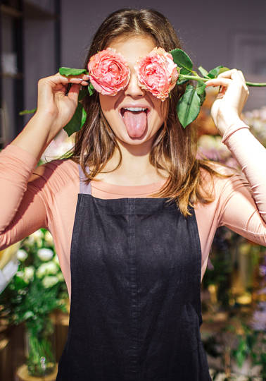 Closing the missing link Young female florist with flowers in front of eyes.