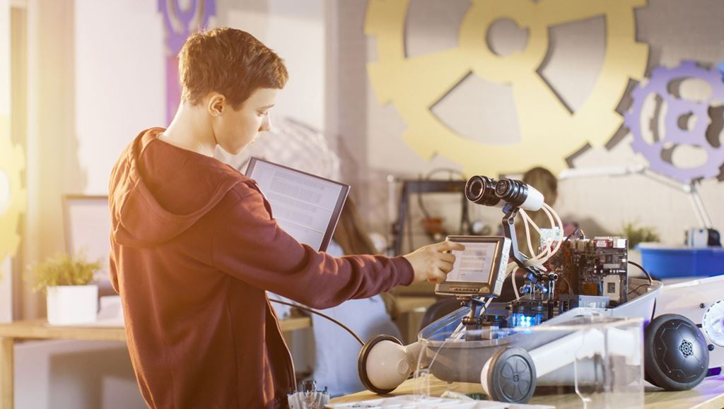 Boy touching the screen of a robot