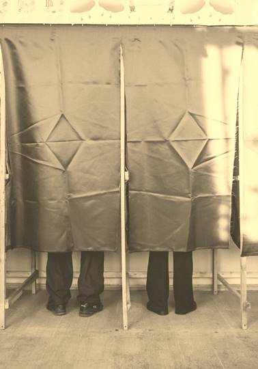 People at polling station voting behind curtain