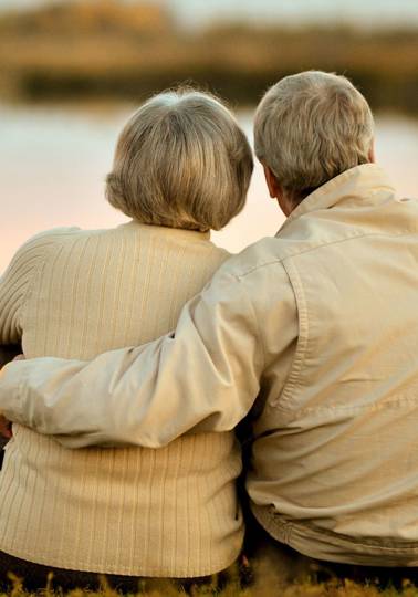 Helping people understand inheritance Elderly couple embracing looking out at a lake