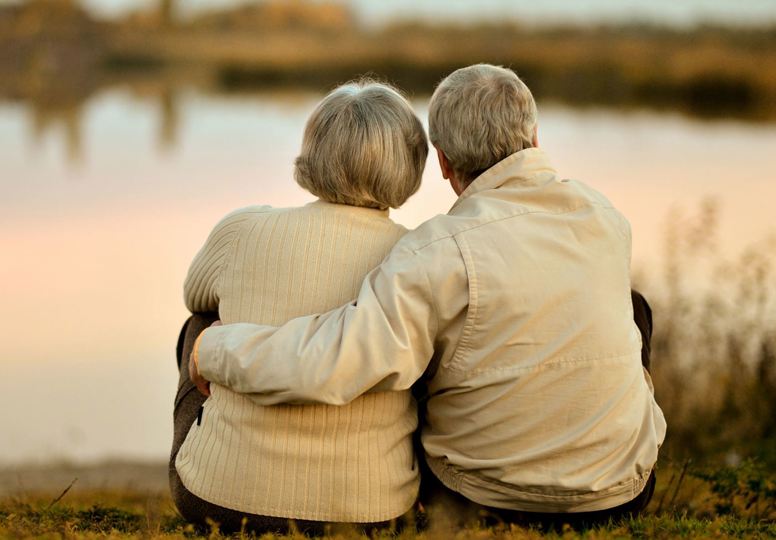 Helping people understand inheritance Elderly couple embracing looking out at a lake