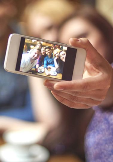 Lady taking a selfie with a small group of people