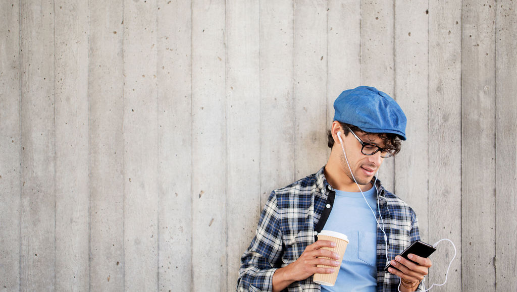 New podcast to promote EU-funded research Young man in blue hat holding coffee and phone listening to a podcast