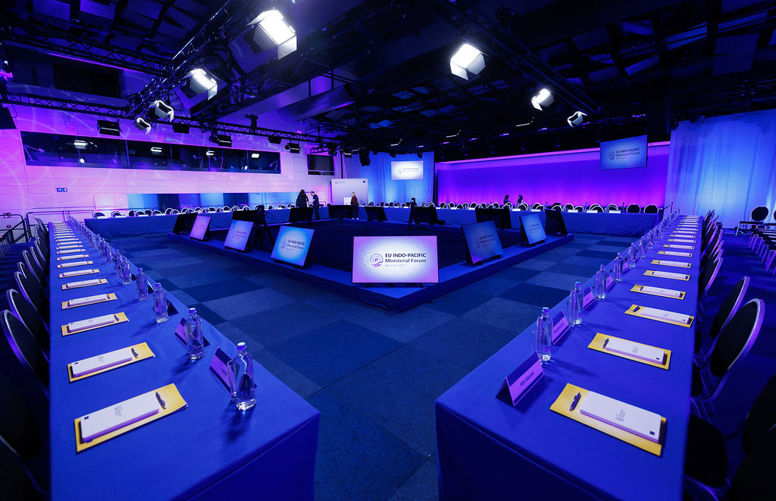 photo of the Forum room with screens, chairs and purple lighting.