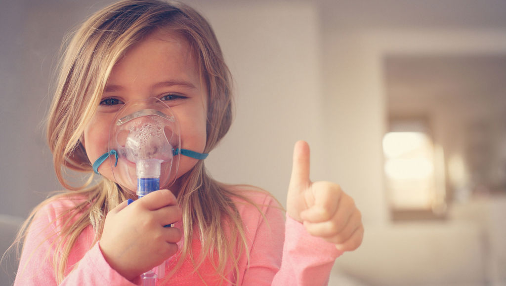 Hope for people with rare diseases Little girl using inhaler and showing OK.