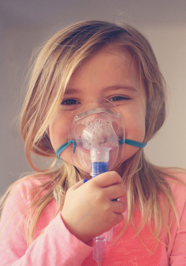 Hope for people with rare diseases Little girl using inhaler and showing OK.