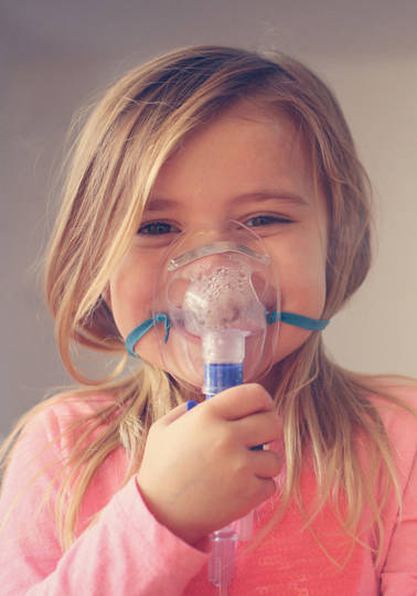 Hope for people with rare diseases Little girl using inhaler and showing OK.