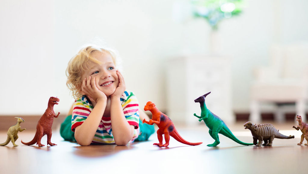 Child playing with dinosaur toys