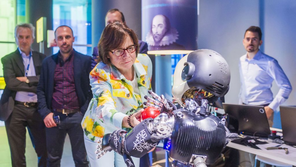 Making science wonder-ful! Group of men watching a woman interact with a robot