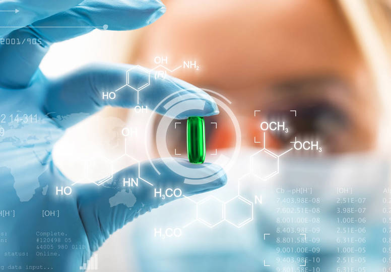 Young female scientist holding a transparent red pill