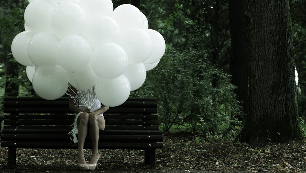 The data protection revolution explained Girl sat on bench with head obscured by bunch of white balloons
