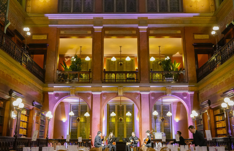 photo of the room for the formal dinner in ornate building, tables set.