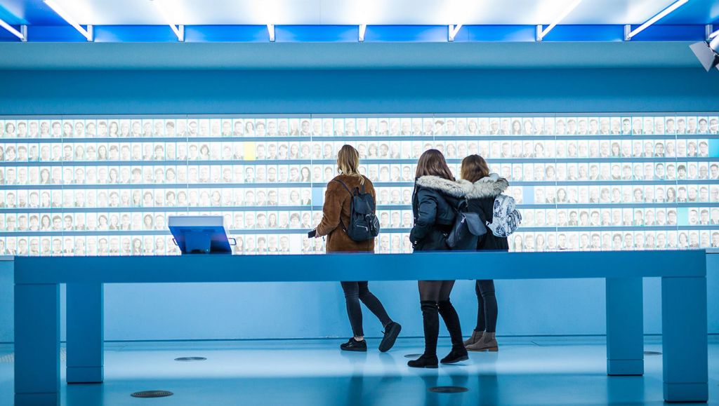 Consumer Classroom competition winners come to Brussels Three young girls looking at hundreds of images of faces on a wall